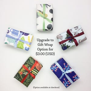 Puede incluir: Cinco cajas de regalo envueltas en papel con diferentes patrones y con cintas azules, rojas y verdes. El texto de la imagen dice "Upgrade to Gift Wrap Option for $3.00 (USD)" y "(Option available at checkout)".