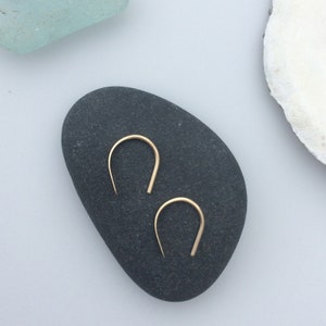 Puede incluir: Un par de pendientes de aro de oro con un dise&ntilde;o simple y minimalista. Los pendientes son peque&ntilde;os y delicados, y son perfectos para el uso diario.