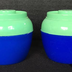 May include: Two salt and pepper shakers with a green top and a blue bottom.