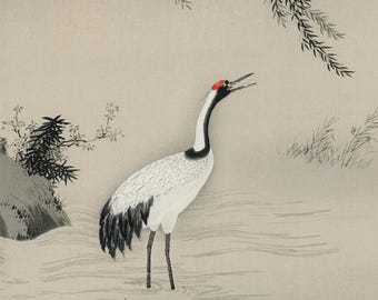 Op de afbeelding: Een schilderij van een witte kraanvogel met zwarte vleugelveren en een rode vlek op de kop. De vogel staat met een geopende snavel in ondiep water. De achtergrond toont een grijs landschap met een donkere rots en wat vegetatie.