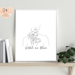 May include: Black and white line art print of a woman with flowers on her chest. The text "Watch me Bloom" is below the woman.