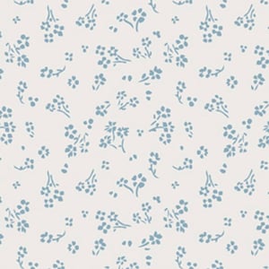May include: A white fabric with a repeating pattern of small blue flowers. The fabric is measured with a ruler in inches.
