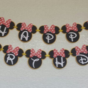 May include: A black and white banner with red polka dots and Minnie Mouse heads. The banner spells out "Happy Birthday".