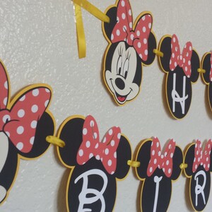 May include: A black and yellow Minnie Mouse themed banner with red polka dot bows and the words "Happy Birthday" in white.
