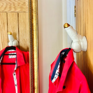 Gancho para toallas de porcelana con forma de pene y perilla fálica erecta