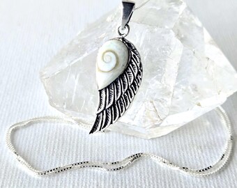 May include: A silver necklace featuring a pendant shaped like an angel wing. The upper portion of the wing is inlaid with a smooth, white, teardrop-shaped shell displaying a natural spiral pattern. The lower part of the wing is textured silver.