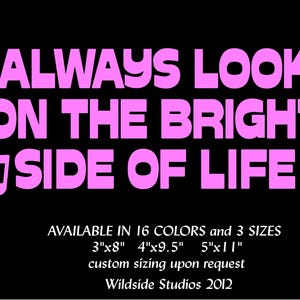 May include: A black decal featuring the pink text ALWAYS LOOK ON THE BRIGHT SIDE OF LIFE surrounded by pink musical notes. Text below indicates availability in 16 colors and 3 sizes: 3 inches by 8 inches, 4 inches by 9.5 inches, and 5 inches by 11 inches.