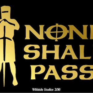 May include: A black graphic print featuring a gold silhouette of a knight in a helmet holding a sword. The text reads NONE SHALL PASS in gold capital letters, with a cross symbol replacing the letter O. Wildside Studios 2016 is at the bottom.