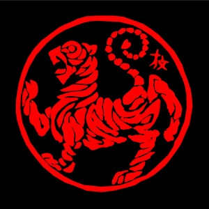 May include: A red tiger illustration inside a red circular border on a black background. The tiger is depicted in a dynamic pose, with its mouth open and a curled tail. Japanese characters are visible.