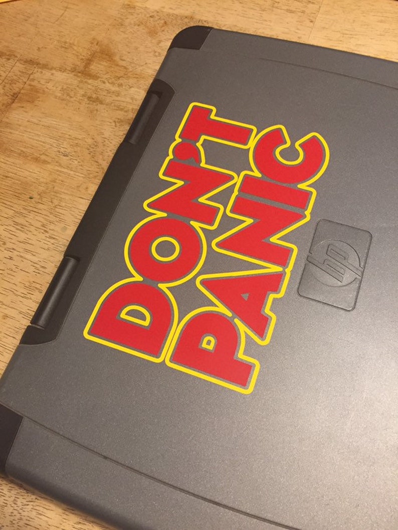May include: A gray laptop with a red and yellow sticker that says "DON'T PANIC".