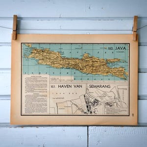 Puede incluir: Mapa antiguo de Java, Indonesia, con detalles geográficos y texto. El mapa, impreso en papel envejecido, está sujeto con pinzas de madera sobre un fondo de madera azul claro. El mapa incluye el texto "160. JAVA" y "161. HAVEN VAN SEMARANG".