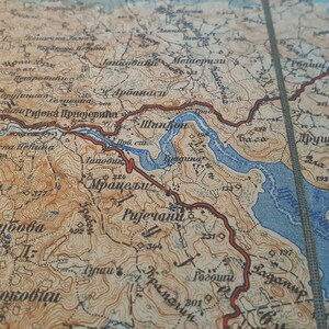 May include: A detailed vintage map with a tan and blue color scheme. The map features geographical details, including rivers, mountains, and place names. The map's aged appearance suggests it is an antique.