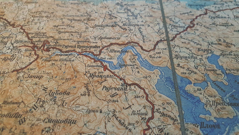 May include: A detailed vintage map with a tan and blue color scheme. The map features geographical details, including rivers, mountains, and place names. The map's aged appearance suggests it is an antique.