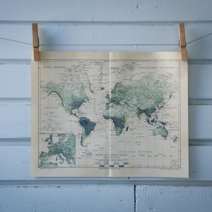 Puede incluir: Un mapa del mundo vintage impreso en papel, colgado en una pared azul claro con dos pinzas de madera.