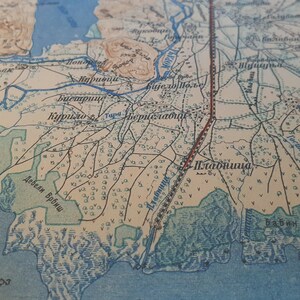 May include: Antique map with detailed cartography. The map features a network of rivers, roads, and settlements, with text labels in a foreign language. The color palette includes shades of beige, blue, and brown, giving it a vintage aesthetic.