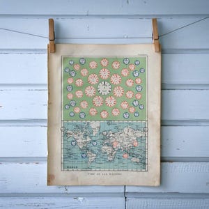 Puede incluir: Impresión de mapa del mundo vintage, sujeta con pinzas de madera sobre un fondo de madera azul claro. El mapa presenta una sección superior verde con ilustraciones de relojes y una sección inferior que representa un mapa del mundo con zonas horarias.