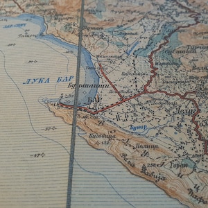 May include: Vintage map with text in a foreign language, featuring coastal regions and geographical details. The map has a faded, aged appearance with blue, brown, and beige tones. The text includes the words "ЛУКА БАР" and "СТ. БАР".