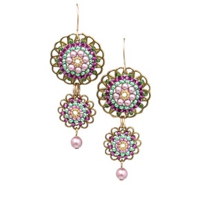 Peut inclure: Boucles d'oreilles pendantes avec un motif floral. Les boucles d'oreilles présentent un cadre en filigrane doré, avec un centre perlé dans les tons de rose, de vert et d'or. Une perle rose pend du bas de chaque boucle d'oreille.