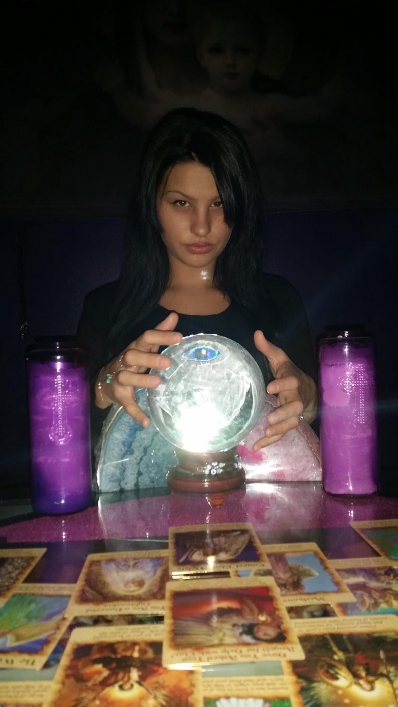Candid photo of Psychic Amanda smiling warmly in her cozy reading room, with gentle trails of incense smoke drifting peacefully in the background.