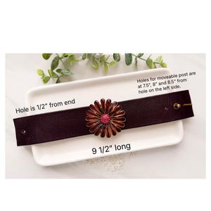 Puede incluir: Una pulsera de cuero marr&oacute;n oscuro con un adorno central en forma de flor con p&eacute;talos granates y un centro de cristales rosas. La pulsera mide 9,5 pulgadas de largo, con un agujero a 0,5 pulgadas del extremo y agujeros ajustables a 7,5, 8 y 8,5 pulgadas.