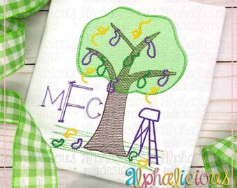 May include: Embroidered design of a green tree with purple beads hanging from the branches. The tree is on a white background with the letters "M F C" stitched in purple below the tree. A small purple stool is to the right of the tree.