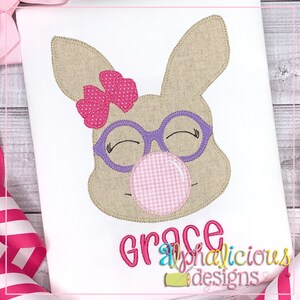 May include: Embroidered design of a brown bunny with pink bow, purple glasses, and a pink bubble. The bunny is smiling and has its eyes closed. The text "Grace" is embroidered below the bunny.