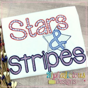 May include: Embroidered design featuring the words "Stars & Stripes" in red, white, and blue with a star and ampersand in the center. The design is on a white t-shirt.
