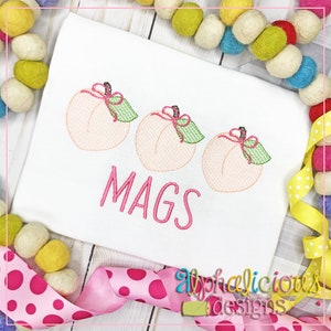 May include: Embroidered design of three pink peaches with green leaves and pink bows, with the name "MAGS" embroidered below.