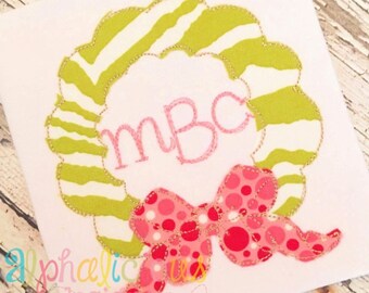 Op de afbeelding: Een groene en witte gestreepte krans met een roze strik en het monogram "MBC" geborduurd in het midden.