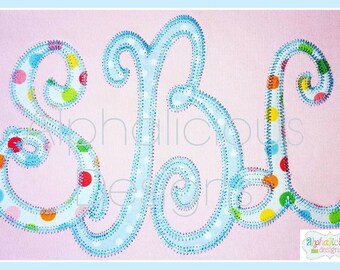 May include: A blue embroidered monogram with the letters "SBL" in a whimsical script font. The letters are outlined in blue and filled with a colorful polka dot pattern.