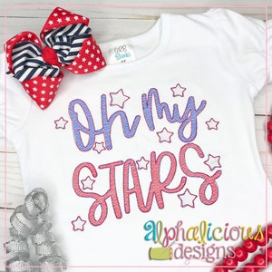 May include: White t-shirt with red and blue embroidery that says "Oh My Stars" with stars surrounding the text. The shirt is decorated with a red and blue bow.