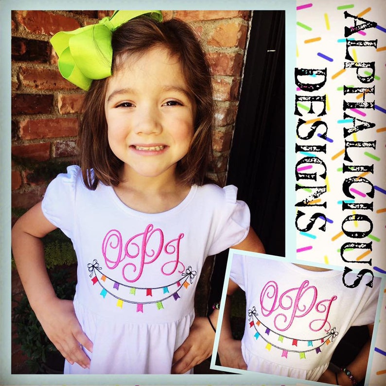May include: A white shirt with pink embroidered letters "OPG" and a colorful banner of flags below. The shirt is worn by a young girl with a green bow in her hair.