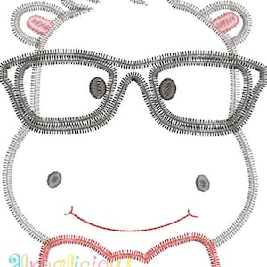 Puede incluir: Diseño bordado de un hipopótamo de dibujos animados con gafas y pajarita. El hipopótamo está delineado en gris con acentos rosas en las orejas y la pajarita. Los ojos son de color gris oscuro y la boca roja. El texto "Alyalicious Designs" está en la parte inferior.