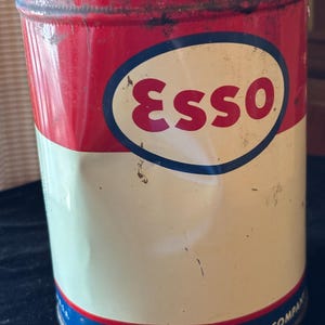 May include: Vintage Esso oil can with a red and white color scheme. The can features the Esso logo in a blue oval and the text "HUMBLE OIL & REFINING COMPANY". The can is marked "NET WEIGHT 5 POUNDS 2.27 KG".