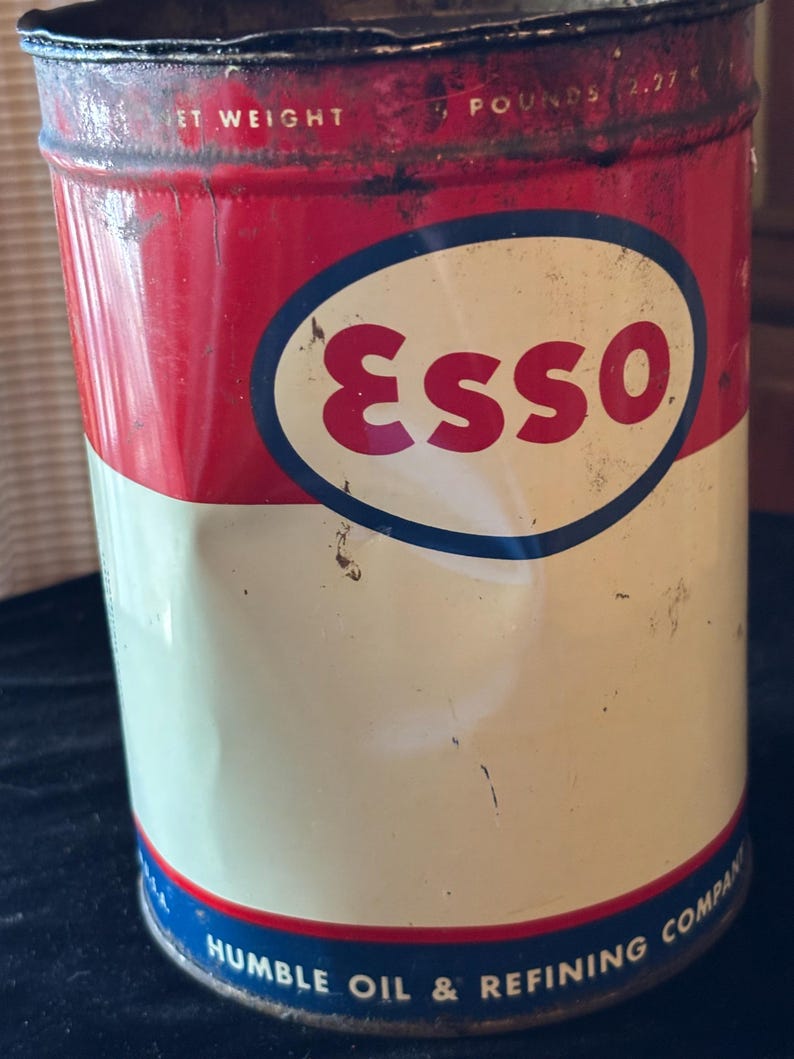 May include: Vintage Esso oil can with a red and white color scheme. The can features the Esso logo in a blue oval and the text "HUMBLE OIL & REFINING COMPANY". The can is marked "NET WEIGHT 5 POUNDS 2.27 KG".