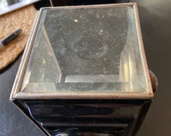 May include: Black metal outdoor light fixture with a clear glass panel and a round base.