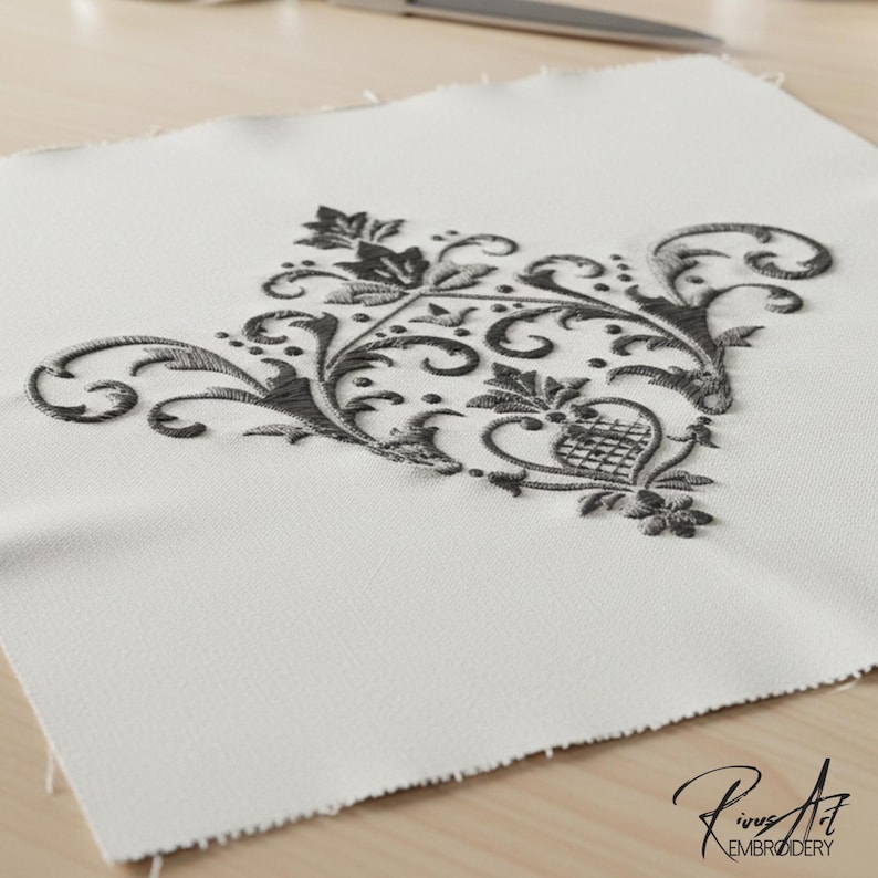 May include: A square, off-white fabric piece with a detailed, dark gray embroidered floral design. The embroidery features swirling vines, leaves, and floral elements. The bottom right corner has the text "Rivus Art EMBROIDERY".
