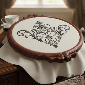 May include: A detailed embroidery project in a wooden hoop. The design features a black floral pattern on a cream-colored fabric. The wooden hoop is a rich brown color. Other sewing supplies are on the table.