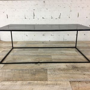 May include: A black metal coffee table with a rectangular top and a simple, open frame design.
