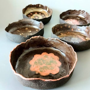 May include: A set of three ceramic mugs with a speckled, matte finish. The mugs are in shades of cream, light gray, and dark gray. Each mug has a simple, modern design and a rounded handle. Perfect for coffee or tea.