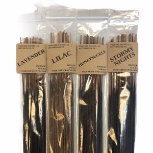 May include: Four packages of incense sticks with brown paper labels. The labels have the names "Lavender", "Lilac", "Honeysuckle", and "Stormy Nights" printed on them. Each package contains a bundle of incense sticks.