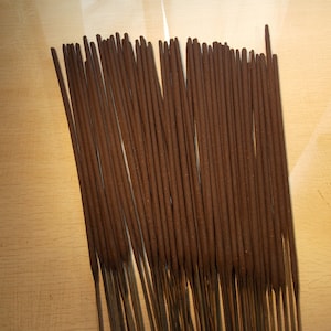 Op de afbeelding: Een bundel bruine wierookstokjes, gerangschikt in rijen, klaar om te worden gebruikt voor meditatie of spirituele praktijken.