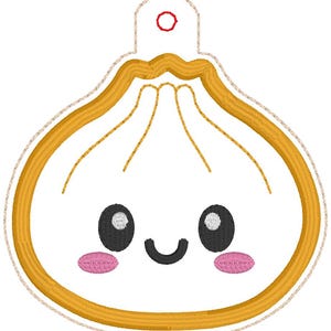 May include: An embroidered patch shaped like a dumpling with a golden yellow outline, a white center, and a smiling face. The face features two large black oval eyes with white highlights, a black curved mouth, and two small pink oval cheeks.