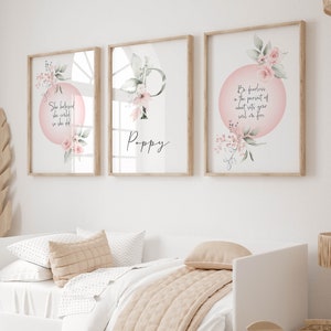 May include: Three framed prints with watercolour floral designs and inspirational quotes. The first print features a pink circle with the quote "She believed she could so she did". The second print features a pink floral design with the letter "P" and the name "Poppy" below. The third print features a pink circle with the quote "Be fearless in the pursuit of what sets your soul on fire".