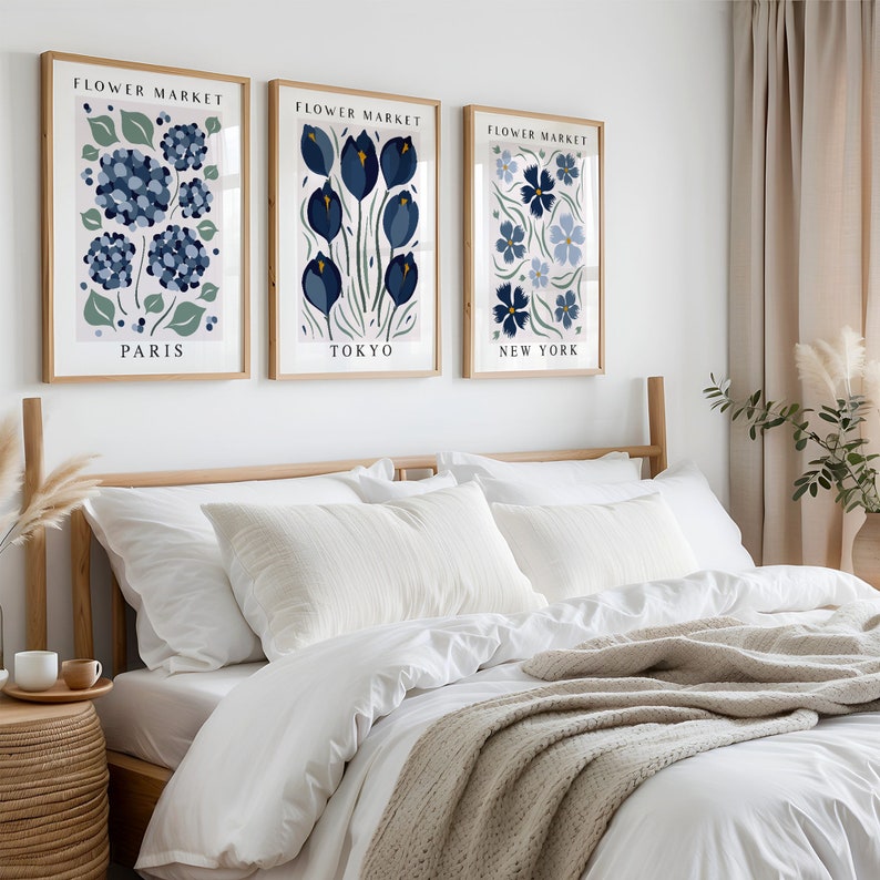 May include: Three framed prints with a white background and blue floral illustrations. The prints are titled "Flower Market" and each features a different city: Paris, Tokyo, and New York.