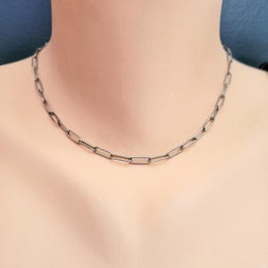 May include: A silver chain necklace with a simple, linked design. The chain is made of small, rectangular links.