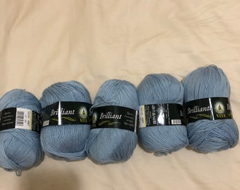 May include: Four balls of light blue yarn labeled "Brilliant" with the Vita logo. The yarn is for knitting or crocheting.
