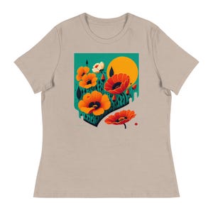 Może przedstawiać: Beżowa koszulka z kolorowym kwiatowym wzorem. Grafika zawiera pomarańczowe maki, żółte słońce i turkusowe tło. Kwiaty są stylizowane czarnymi konturami i zielonymi łodygami.