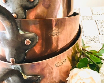 May include: A set of three vintage copper pots with black handles. Each pot has a circular embossed label that reads "Etablissements Allez Freres Paris".