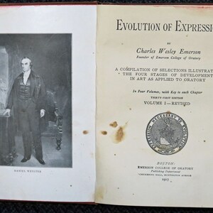 Op de afbeelding: Een zwart-wit portret van Daniel Webster, een prominente Amerikaanse staatsman en redenaar, staat op de linkerpagina. De rechterpagina toont de titel "Evolution of Expression" van Charles Wesley Emerson, oprichter van Emerson College of Oratory. Het boek is een compilatie van selecties die de vier stadia van ontwikkeling in de kunst illustreren, zoals toegepast op de oratoriumkunst. Het is de eenendertigste editie en het eerste deel, dat is herzien.